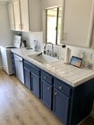 Upper cabinets are painted white while the lowers are blue with polished brass hardware. - 23705 Sea Breeze Ln Condo Unit 23705