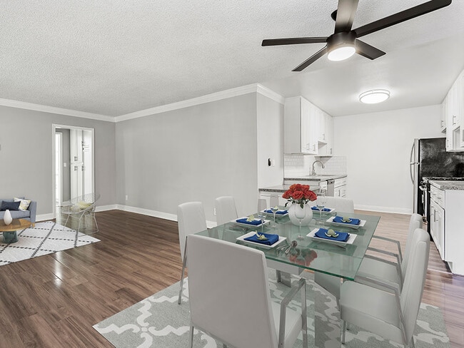 Large hardwood floored dining room with view of kitchen. - National Apartments