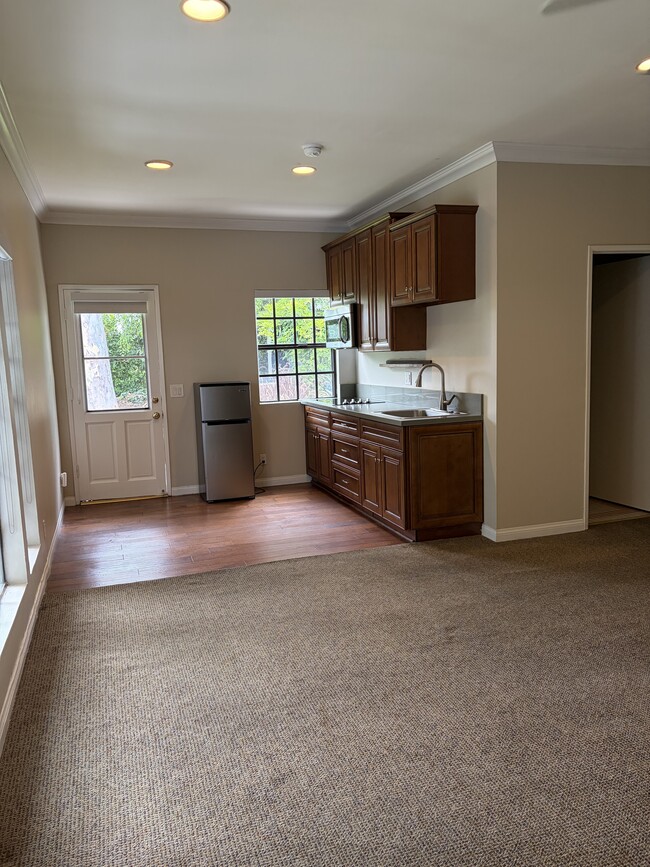 Wall kitchen with wood cabinets. Microwave, fridge and stovetop. Space fir small table - 665 Rim Rd Unit Pasadena Studio Bungalow