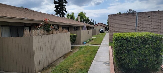 Private patios along walkways to apartments at Las Casitas Apartments in Riverside, California. - Las Casitas Apartments