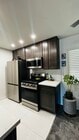 New kitchen with stainless steel refrigerator, dishwasher, stove with built-in air fryer, microwave - 6600 Warner Ave Unit Modern Condo