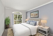 Carpeted bedroom featuring beautiful natural lighting and ceiling fan. - Chateau Encino Apartments