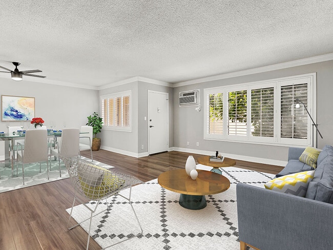 Hardwood floored living room with view of dining area. - National Apartments