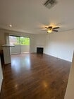 Living room with balcony & gas fireplace and ceiling fan light - 10330 Riverside Dr Townhome