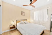 Stylish bedroom with modern fan, warm lighting, and cheerful décor. - 1013 S Sunshine Ave Condo Unit K
