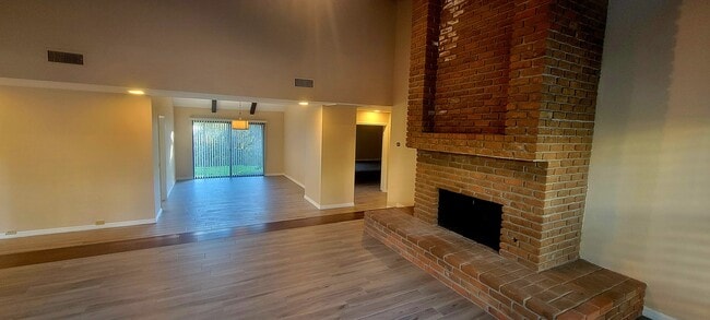 Living room with brick fireplace and dining room - 16139 Ladera Piedra Way