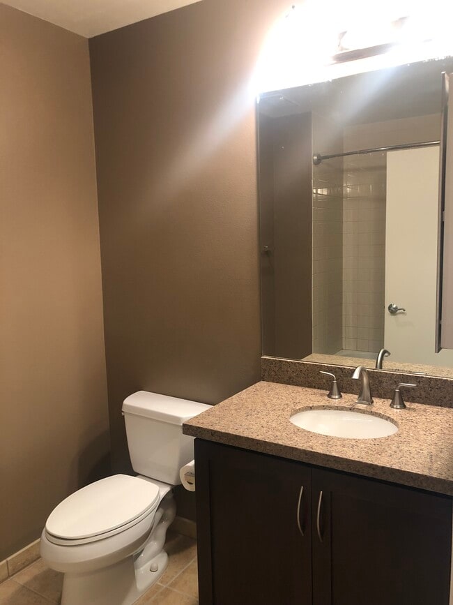 Full Bath with granite countertops, dark wood cabinets, & tile floors - 427 9th Ave Unit 907