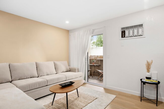 Spacious lounge with comfy sofa and patio access – ideal for indoor-outdoor living. - 1013 S Sunshine Ave Unit K