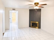 Spacious living room featuring a decorative fireplace, neutral walls, tile flooring, and a comfortab - 339 E Taft Ave Unit 2