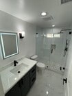 Fully updated bathroom featuring a walk-in glass shower, custom tile work, LED mirror, modern vanity - 327 Aliso St
