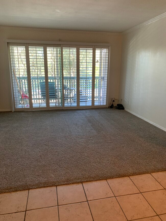 Living room with plantation shutters and new white vinyl double paned sliding glass doors - 436 N Bellflower Blvd Unit 218