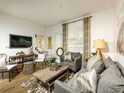 Open floor plan with spacious living room and white kitchen cabinets - Stone Creek Apartments