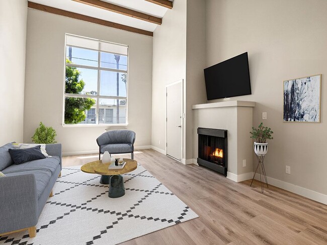 Hardwood floored living room with fireplace and large window to outdoors. - The Glendon Building