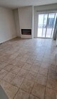 Sunny living room with fireplace opens to kitchen and balcony. - 314 20th St Unit D