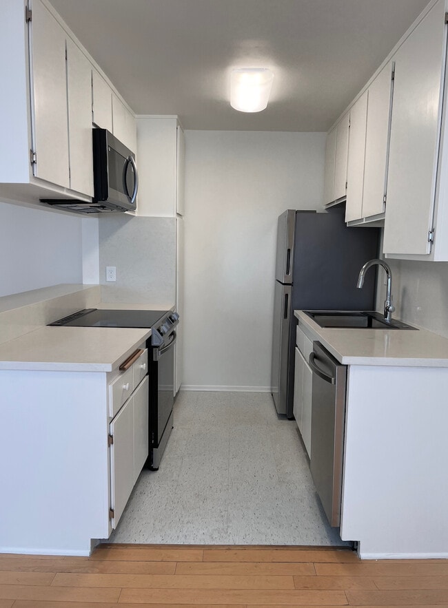 Renovated kitchen with quartz countertops and stainless steel appliances. - 11639 Chenault St Unit 403