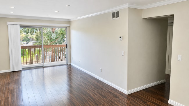 Living Room: Bright, spacious living room with wood-look flooring and recessed lighting. - 6191 Rancho Mission Rd Unit 108