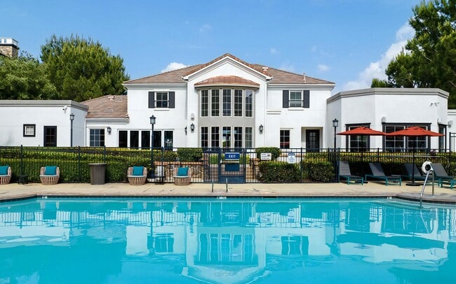 Poolside View Facing Clubhouse with Lounge Chairs and Umbrellas - Villas at the Gardens