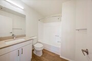 Renovated Package Bath with white cabinetry, grey quartz countertop, and hard surface flooring - eaves La Mesa