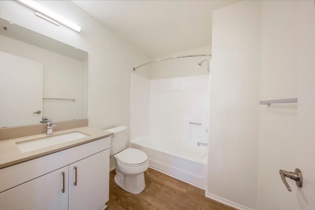 Renovated Package Bath with white cabinetry, grey quartz countertop, and hard surface flooring - eaves La Mesa