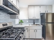 Tiled kitchen with stainless steel fridge, oven, and miocrowave. - Olive View Gardens