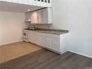 Kitchen w/ gas stove & cabinetry - 5820 Calvin Ave