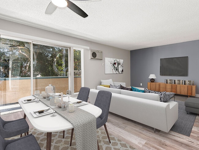 Hardwood floored dining room with ceiling fan and view of living room and private balcony. - Olive View Gardens