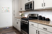 Brand new backsplash and hardware on the shaker-style cabinets - Mira Bella Apartments