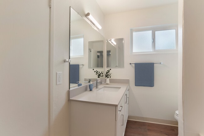 Renovated Package I bath with white cabinetry, beige granite countertops, and hard surface flooring - eaves Mission Ridge
