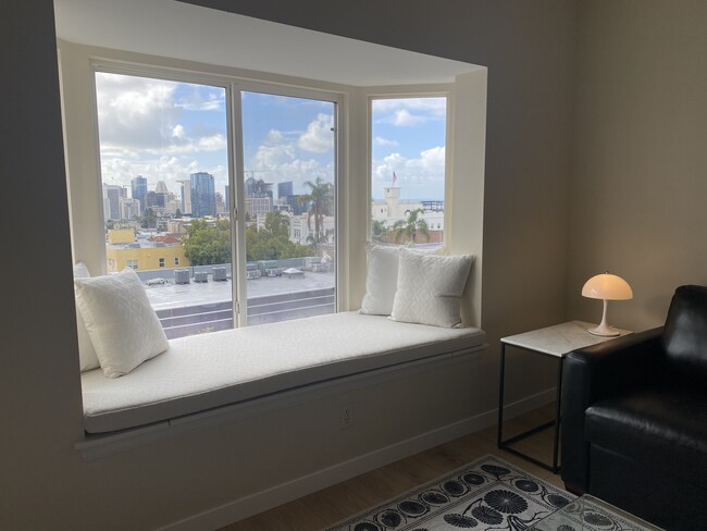 Window seating with panoramic city and bay views from the living room. - 2400 5th Ave Condo Unit 432