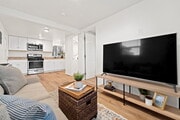 Living room, kitchen, doors to bathroom and bedroom - 4510 48th St Apartments Unit 1BR