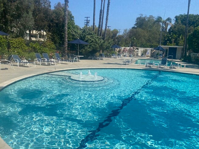 Resort style pool with fountain, lounge chairs, saltwater pool and spa, bathrooms and changing rooms - 241 S Barrington Ave Unit 4