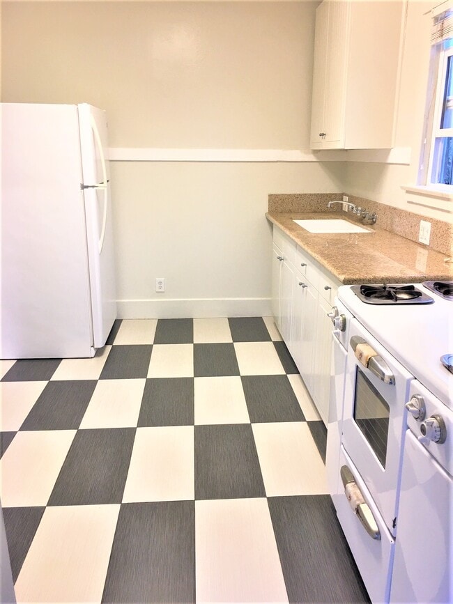 Kitchen granite countertop and tiled floor, refrigerator and stove - 3047 E 6th St Unit 3047 East 6th Street