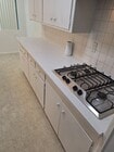 Kitchen Quartz Counter Stove - 3229 Glenhurst Ave Apartments