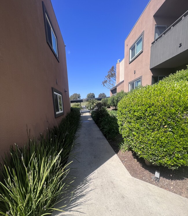 Walkway between apartment buildings at Villa Pacific Apartments in Oceanside, California. - Villa Pacific Apartments