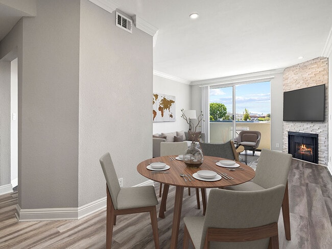 Hardwood floored dining room with view of balcony and stone walled fireplace. - Palms Court