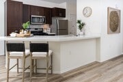 Bright Kitchen with Extended Countertop Seating and Decorative Wall Art - Camino Real Apartments