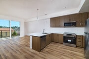 Host friends easily around premium quartz countertops and a spacious kitchen breakfast bar. - textur Apartments