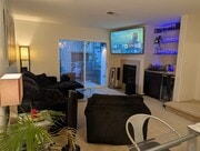 Furnished living room with TV, fireplace, bar, mini-fridge, and hidden entertainment center. Balcony - 3542 Shoreline Bluff Lane