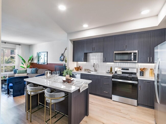 Our gourmet kitchens feature sleek quartz countertops, elegant tile backsplashes, and 42-inch custom cabinetry, offering both beauty and functionality. Elevate your culinary experiences in a space designed for chefs and food enthusiasts alike. - Modera Pomona