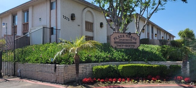 Gated front enterance with lush gardens at Plaza Verde Apartments in  Escondido, California. - Plaza Verde Rental