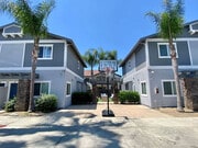 Community area with backetball hoop and sitting area in background at The Nines Townhomes in Escondido, California. - The Nines Townhomes