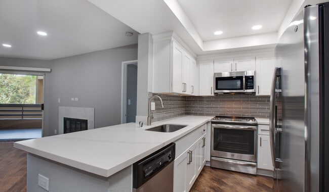 Kitchen complete with quartz countertops and wood flooring - 3400 Avenue Of The Arts