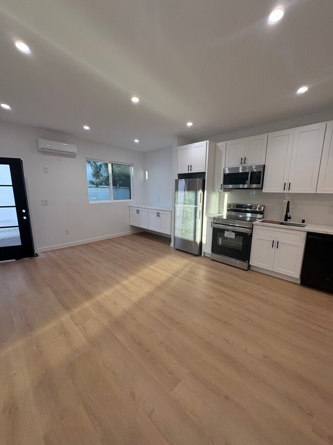 Open concept living room, dining room, and kitchen with brand new appliances. - 7834 S Harvard Blvd Unit 7836 S Harvard