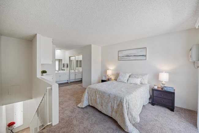 Spacious bedroom at the Terrace apartment in Tarzana, CA with mirrored closets and ample natural light - The Terrace