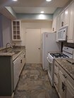 Full kitchen with pantry door - 10021 Tabor St Condo Unit #206