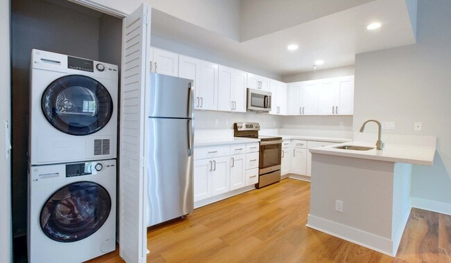 Renovated kitchens with stackable laundry in-unit. - Island Club Apartments