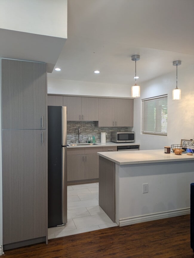 Modern kitchen with Euro cabinets, quartz countertops, and new stainless steel appliances - 5652 Yolanda Ave Unit #9