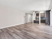 Hardwood floored living room with view of dining area and kitchen. - Olive View Gardens