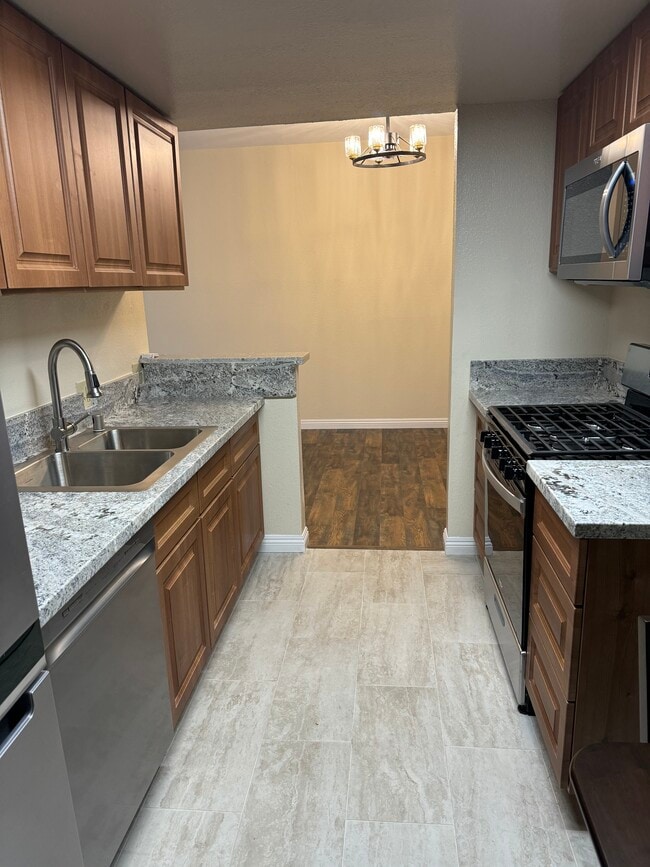 Kichen with SS appliances, marble counters and porcelain tiles. - 10824 Palms Blvd Unit 3
