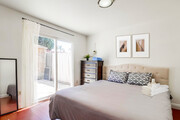 The master has a cozy king bed. Plus, a glass sliding door leading to the outdoor backyard. - 2304 E 14th St House